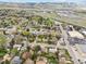 Spacious aerial view captures homes, a highway, shopping destinations, mountains, and a clear blue sky at 320 Orion St, Golden, CO 80401