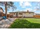 Spacious backyard with lush green grass, a small patio area, and a well-maintained fence at 320 Orion St, Golden, CO 80401