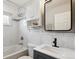 Bathroom features a shower and tub combination, white tile, and storage cabinets at 320 Orion St, Golden, CO 80401
