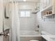 Bathroom with tub and shower, white tile surround, and vanity with black faucet at 320 Orion St, Golden, CO 80401