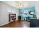 Bedroom with blue accent wall, wood floors, ceiling fan, desk, and a bookcase at 320 Orion St, Golden, CO 80401