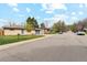 Attractive single-story brick home featuring a well-manicured lawn, mature trees and attached garage at 320 Orion St, Golden, CO 80401