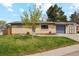 Charming single-story brick home featuring a well-manicured lawn, mature tree and an attached garage at 320 Orion St, Golden, CO 80401