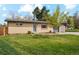 Charming brick house with a well-manicured lawn, mature trees, and an inviting front entrance at 320 Orion St, Golden, CO 80401