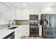 Bright kitchen features white cabinets, stainless steel appliances, and grey subway tile backsplash at 320 Orion St, Golden, CO 80401