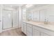 Well-lit bathroom featuring a double sink vanity, quartz countertop, and glass-enclosed tiled shower at 449 S Salida St, Aurora, CO 80017