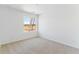 Bright bedroom featuring neutral carpeting, natural light from a large window, and standard electrical outlets at 449 S Salida St, Aurora, CO 80017