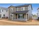 New construction home featuring a covered patio, gray horizontal siding, white trim, and a concrete patio pad at 449 S Salida St, Aurora, CO 80017