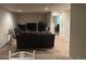 Basement features a dark brown couch, plush carpet, modern lighting, and a doorway to a bedroom at 15501 E 112Th Ave # 28E, Commerce City, CO 80022