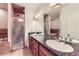 Bathroom with dual sinks, granite counters, and a separate glass door shower at 15501 E 112Th Ave # 28E, Commerce City, CO 80022