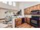Bright kitchen open to living area, showcasing wood floors, granite counters, and black appliances at 15501 E 112Th Ave # 28E, Commerce City, CO 80022