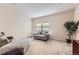 Bright living room features neutral paint, a comfortable loveseat, and a large window for natural light at 15501 E 112Th Ave # 28E, Commerce City, CO 80022