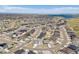 Extensive aerial view showcasing a vibrant community with numerous houses, roads, and green spaces near a lake at 7240 S White Crow Way, Aurora, CO 80016