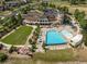 Aerial view of the community clubhouse complex with a large pool, sunbathing area, and manicured lawn at 7240 S White Crow Way, Aurora, CO 80016