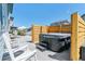 Relaxing backyard with a hot tub, modern wooden screen, lounge furniture, and a sunny patio at 7240 S White Crow Way, Aurora, CO 80016