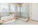 Bright bathroom featuring a soaking tub, a glass shower, and storage at 7240 S White Crow Way, Aurora, CO 80016