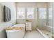 Bright bathroom featuring a soaking tub, a glass shower, and storage at 7240 S White Crow Way, Aurora, CO 80016