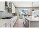 Bright kitchen with stainless steel appliances, white cabinetry, and a large window overlooking the backyard at 7240 S White Crow Way, Aurora, CO 80016