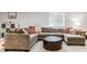Spacious living room with gray sectional sofa and an ottoman coffee table, and neutral decor at 7240 S White Crow Way, Aurora, CO 80016