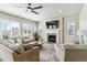 Cozy living room with a fireplace, plush seating, large windows, and ample natural light at 7240 S White Crow Way, Aurora, CO 80016