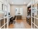 This home office is well-lit, featuring a desk, shelving, and a window at 7240 S White Crow Way, Aurora, CO 80016