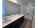 Spacious bathroom with double sinks, large mirror, and walk-in shower at 6599 N Netherland St, Aurora, CO 80019