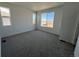 Spacious bedroom with carpet, white walls, and multiple bright windows at 6599 N Netherland St, Aurora, CO 80019
