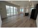 Open-concept living space with wood-look floors, island and sliding doors to outdoor balcony at 6599 N Netherland St, Aurora, CO 80019