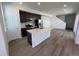 Bright living room featuring an island, modern appliances, and hardwood floors at 6599 N Netherland St, Aurora, CO 80019