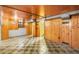 Basement featuring paneled walls, drop ceiling, and checkered flooring at 3226 S Grant St, Englewood, CO 80113