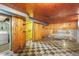 Basement featuring paneled walls, drop ceiling, and checkered flooring at 3226 S Grant St, Englewood, CO 80113