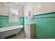 Bathroom featuring a classic clawfoot tub and green tiling at 3226 S Grant St, Englewood, CO 80113