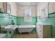 Bathroom featuring a classic clawfoot tub and green tiling at 3226 S Grant St, Englewood, CO 80113
