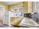 Cozy kitchen featuring bright yellow cabinetry and a stainless steel faucet at 3226 S Grant St, Englewood, CO 80113