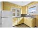Cozy kitchen featuring bright yellow cabinetry and a window overlooking the outdoors at 3226 S Grant St, Englewood, CO 80113