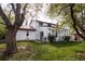 Backyard view with sunroom addition, patio area with grill, and mature trees providing ample shade at 4667 Ashfield Dr, Boulder, CO 80301