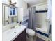 Bright bathroom featuring a white sink, matching toilet, vanity and a shower-tub combo with blue accents at 4667 Ashfield Dr, Boulder, CO 80301