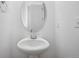 Powder room features a pedestal sink, oval mirror, and neutral walls at 45915 Wood Thrush Ave, Bennett, CO 80102