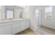 Bathroom with double vanity sinks, a walk-in shower, and wood-look flooring at 45915 Wood Thrush Ave, Bennett, CO 80102