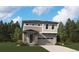Charming two-story home with stone accents, neutral siding, manicured lawn, and attached two car garage at 45915 Wood Thrush Ave, Bennett, CO 80102