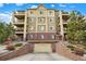 Multi-level condo building with brick accents, several balconies, and attached garage at 1144 Rockhurst Dr # 401, Highlands Ranch, CO 80129