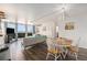 Open-concept living and dining area with balcony access and city views through large windows at 1020 15Th St # 12C, Denver, CO 80202