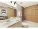 Bathroom with a sink, washer/dryer, and bathtub/shower with tan tile and glass accents at 3341 S Monaco Pkwy # A, Denver, CO 80222