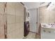 Bathroom featuring a stackable washer/dryer, neutral tile, and a white vanity with sink at 3341 S Monaco Pkwy # A, Denver, CO 80222