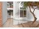 A townhome entrance with a brick accent wall, small porch with hanging plants, and a lush tree at 3341 S Monaco Pkwy # A, Denver, CO 80222
