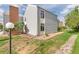 Corner unit townhome featuring vinyl siding, a brick chimney, green lawn, and a rock path at 3341 S Monaco Pkwy # A, Denver, CO 80222