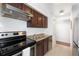 Updated kitchen featuring stainless steel appliances and dark wood cabinets at 3341 S Monaco Pkwy # A, Denver, CO 80222