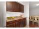 Cozy kitchen featuring dark wood cabinetry, a tan countertop, and white tile backsplash at 3341 S Monaco Pkwy # A, Denver, CO 80222