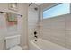 Bathroom area featuring modern tub, shower, and a toilet with neutral color themes at 6366 N Emporia St, Denver, CO 80238