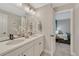 Bathroom featuring double sinks, modern fixtures, and with a view into the bedroom at 6366 N Emporia St, Denver, CO 80238